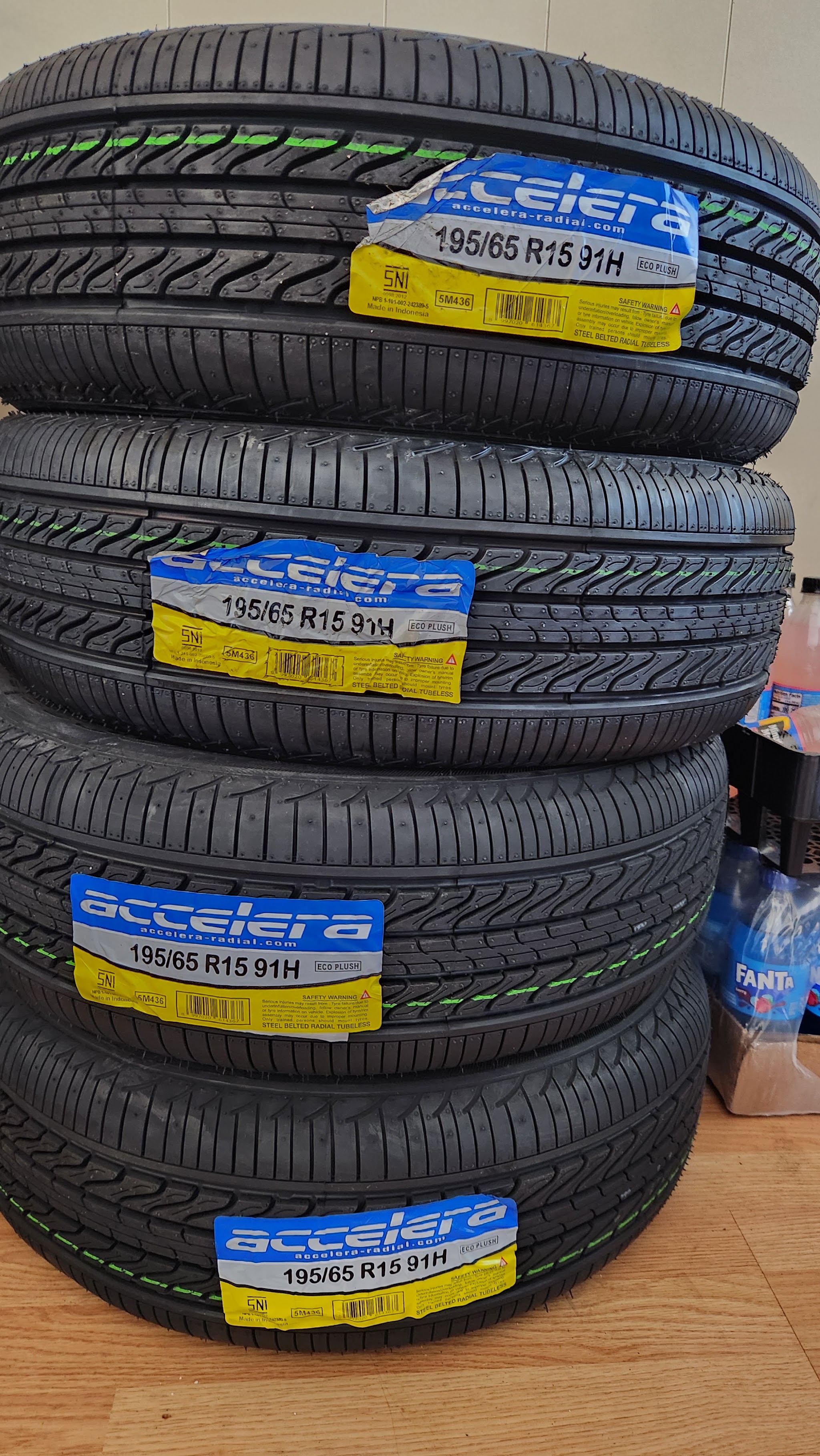 A stack of new tires with size labels